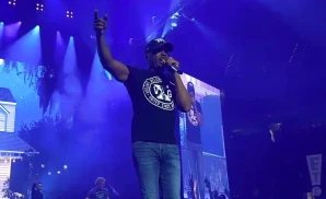 darius rucker performing on stage with blue light in the background