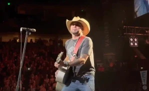 jason aldean performing on stage wearing a cowboy hat