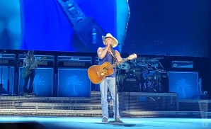 kenny chesney performing on stage holding a guitar