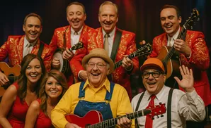 A band of six people in matching red sequined jackets and hats smiles and plays guitars and a banjo.