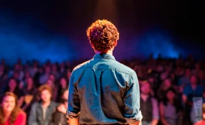 a rear view photograph depicting the view from behind aodán coyne from the band socks in the frying pan performing on stage in front of a large audience