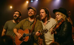 A band performs on stage with a guitarist, singer, and violinist.