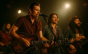 A band performs on stage, with the lead singer playing a guitar and singing into a microphone.