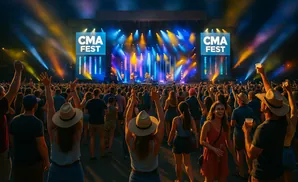 Crowd at CMA Fest with people raising hands and enjoying a concert.