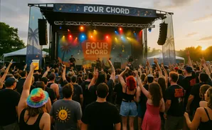 Crowd cheers for a band at the Four Chord Music Festival during sunset.