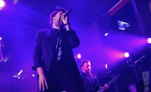 beartooth singer and electric guitarist playing in purple light