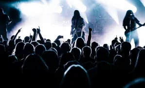 a rear view picture of metal musician helmet performing on stage to a large audience