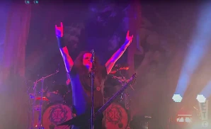 kreator lead singer live on stage holding electric guitar
