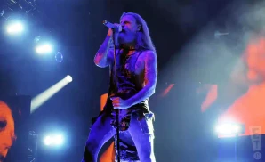 rob zombie holding the mic stand under blue and orange light