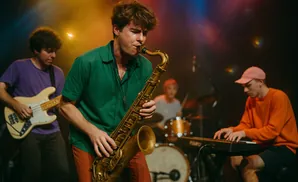 A band plays music on stage with a saxophonist in the foreground.