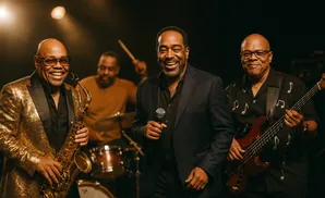 A jazz band with a saxophonist, singer, and bassist on stage.