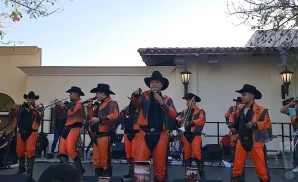 banda maguey in black and orange performing on stage