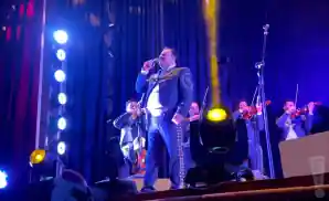 mariachi vargas de tecalitlan singe performing on stage in front of band.