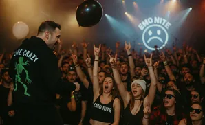 A performer on stage with a crowd cheering at an Emo Nite event.