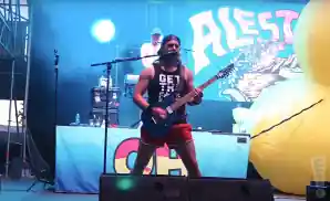 alestorm playing live on stage in front of blue lights.
