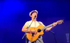 jason mraz playing the guitar and singing live on stage
