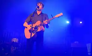 jimmy eat world lead singer singing live on stage with a guitar.