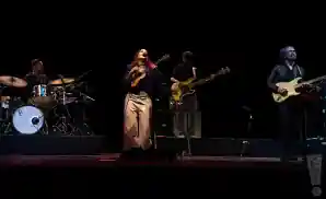 natalia lafourcade performing on stage in front of black backdrop