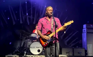 bloc party lead singer singing while playing the electric guitar