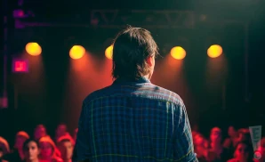 a rear view photo of chance pena performing a concert on stage to a lively audience