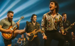 A rock band performs on stage, with the lead singer front and center in a colorful shirt.