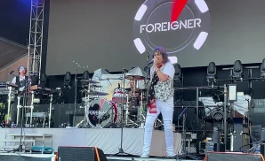foreigner's lead singer singing live with american flag scarf on