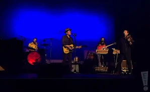 gregory alan isakov performing on stage in front of blue backdrop