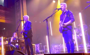 mike gordon playing the bass while singing on stage