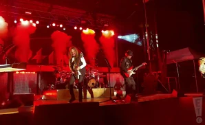 styx performing on stage red smoke in background