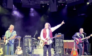 tommy james performing on stage in red vest