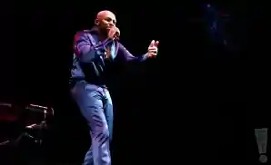 joe performing on stage in a dark blue suit.