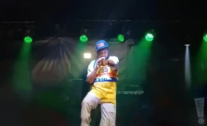 dj quik rapping on stage in basketball jersey