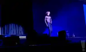 jackson wang performing on stage in front of dark blue background.