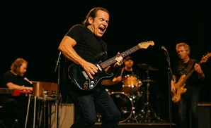 A rock band performs on stage, with a guitarist singing passionately.
