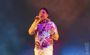 kolohe kai singing on stage in tropical shirt