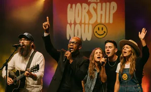 a rear view photo of air1 worship now performing a concert on stage to a lively audience