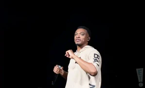 jonathan mcreynolds performing on stage in baige sweatshirt