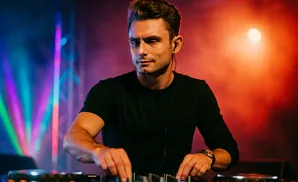 DJ using turntables in a club with colorful lights.