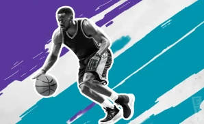 a charlotte hornets basketball player looks down the court with a basketball in his hand