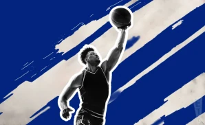 a kentucky wildcats basketball player jumping to tip the ball to gain possession during a game