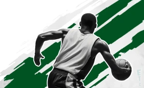 a michigan state spartans basketball player looking down the court and dribbling the ball.