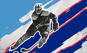 an anchorage wolverines ice hockey player about to hit the puck