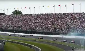 race cars rounding a turn at indianapolis 500 2023.