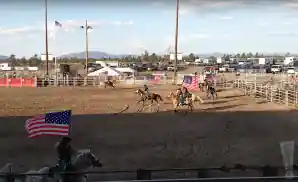 cowboys riding with american flags at the deschutes county fair & rodeo.