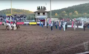 people holding flags in the arena for the 2022 gary hardt memorial rodeo.