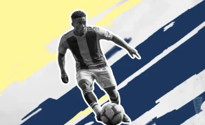 a nashville sc soccer player kicking the ball down field