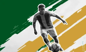 a portland timbers soccer player kicking the ball down field 