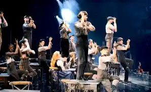 the cast of newsies - the musical posing together on stage.