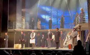 the cast of titanic - the musical on stage together for curtain call.
