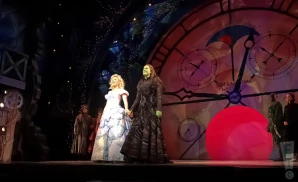 the cast of wicked the musical live on stage posing together.